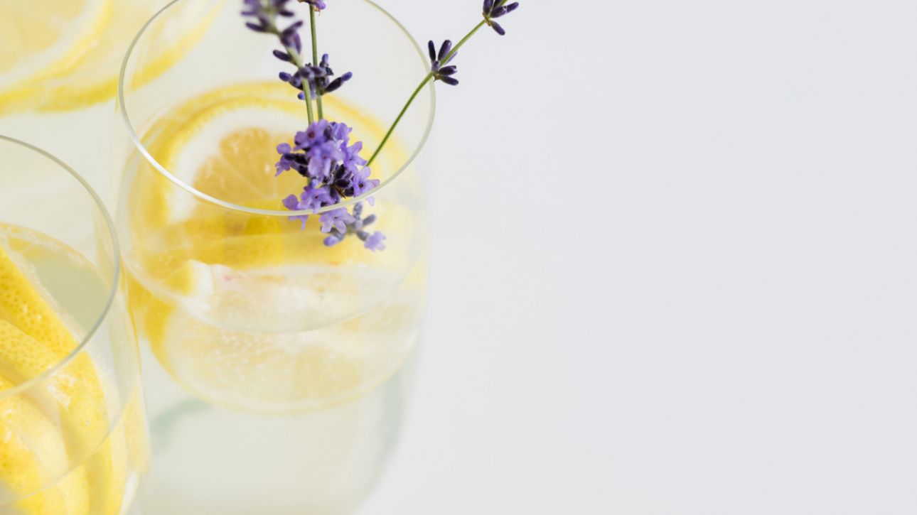 a glass of water with citrus and lavender