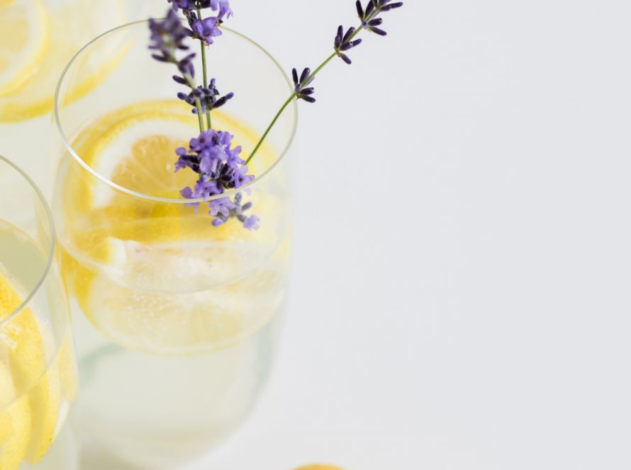 a glass of water with citrus and lavender
